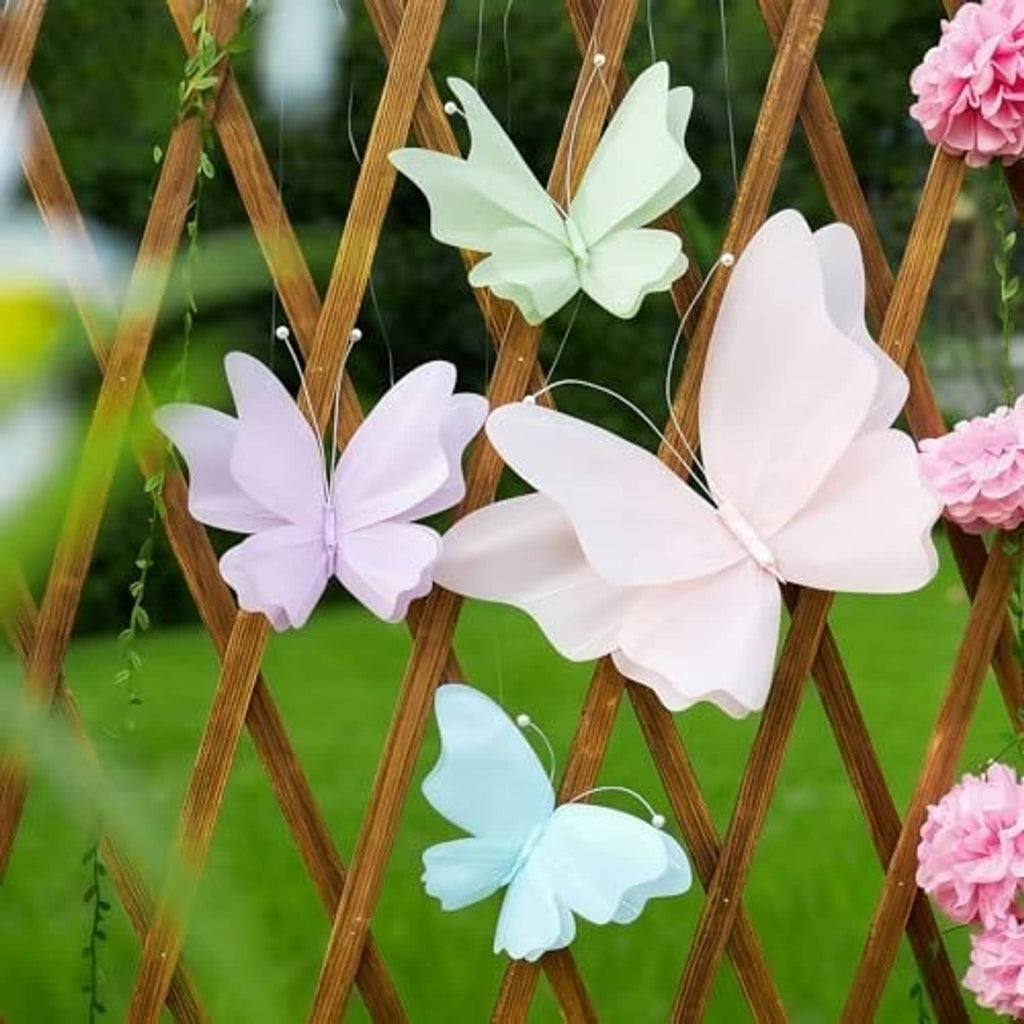 Pastel 3D butterflies with wire antennae hanging on a wooden stand: white, mint, and pink