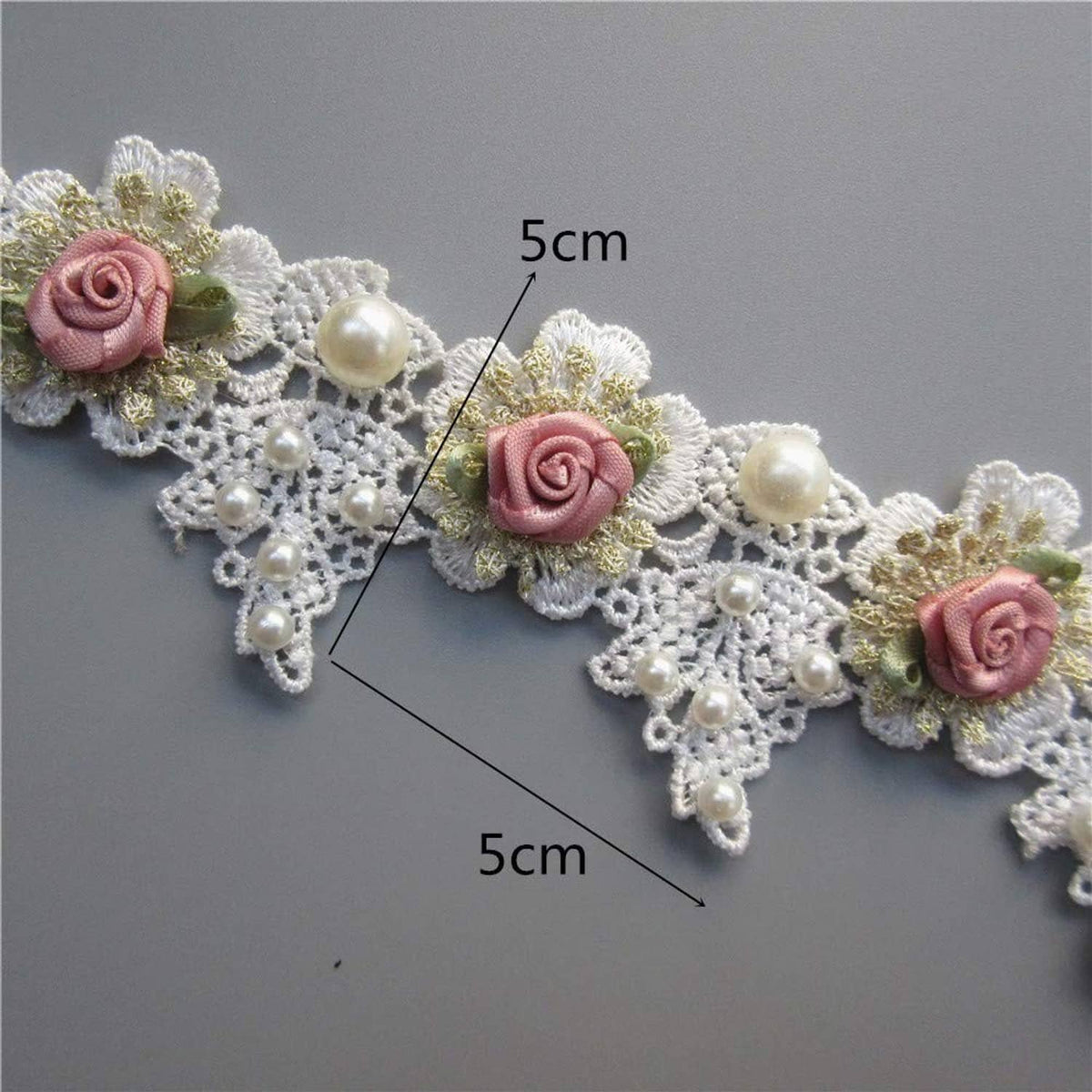 White lace trim with pink roses and pearl beads; labeled 5cm sections