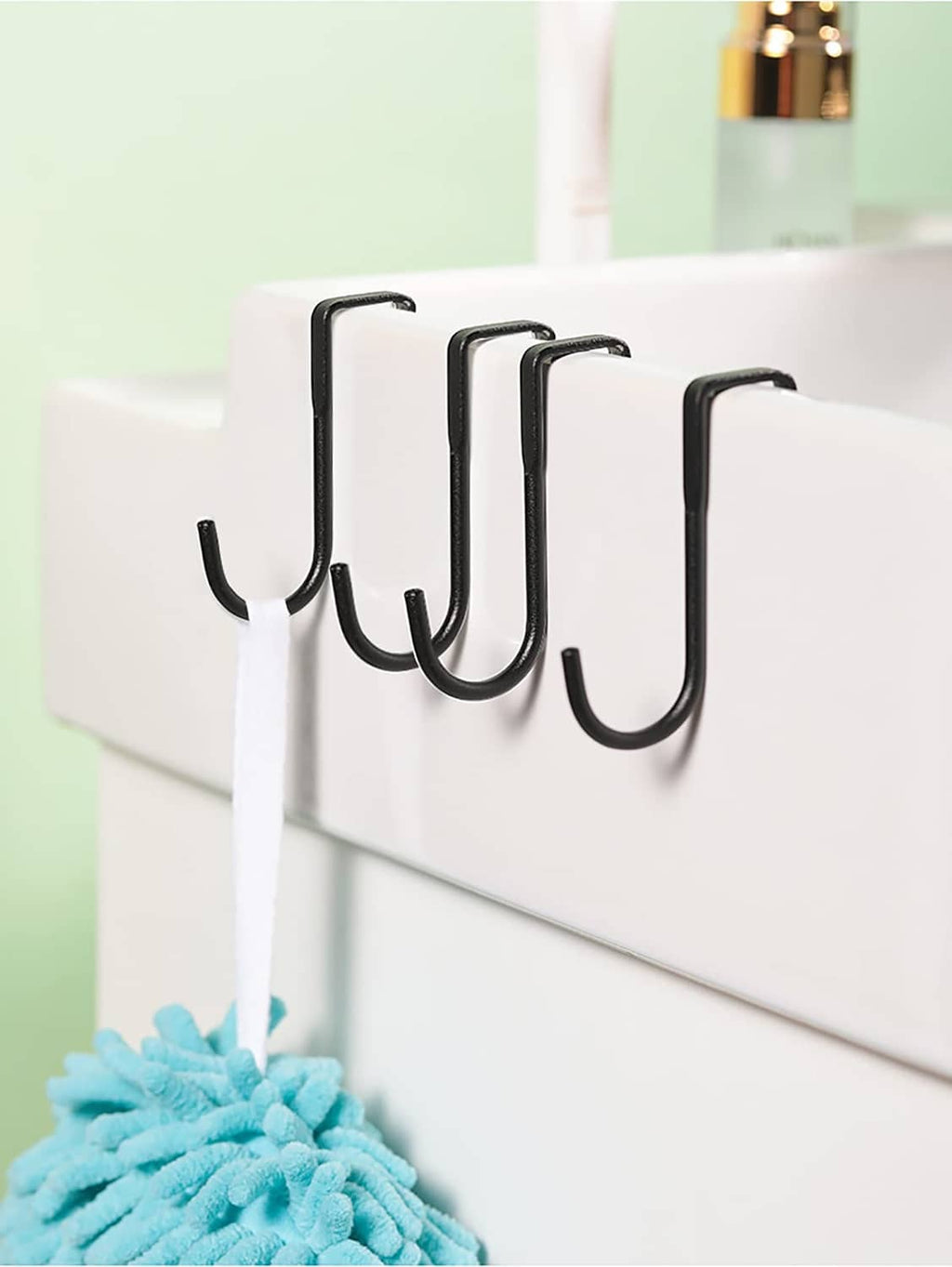 Black shower door towel hooks mounted along cabinet edge with multiple U-shaped hangers