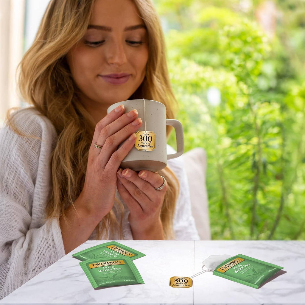 Twinings Pure White Tea mug with green tea bag cartons on a table