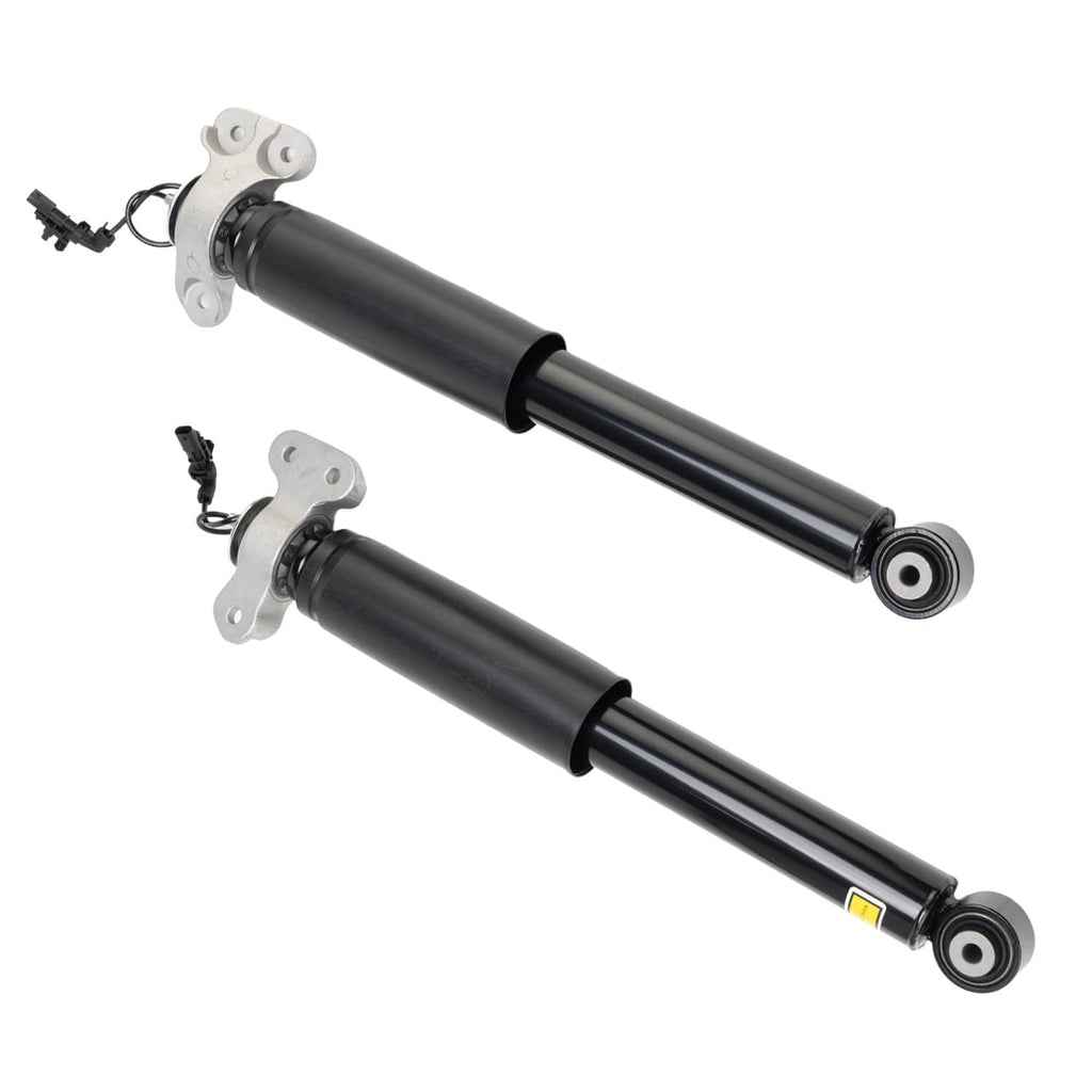 Two rear shock absorbers laid diagonally, black cylinders with silver end mounting brackets