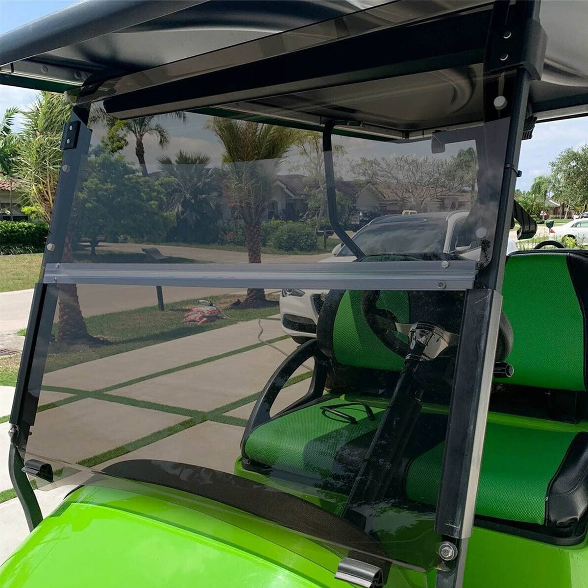 Fold-down tinted windshield installed on a golf cart, clear panel with black frame