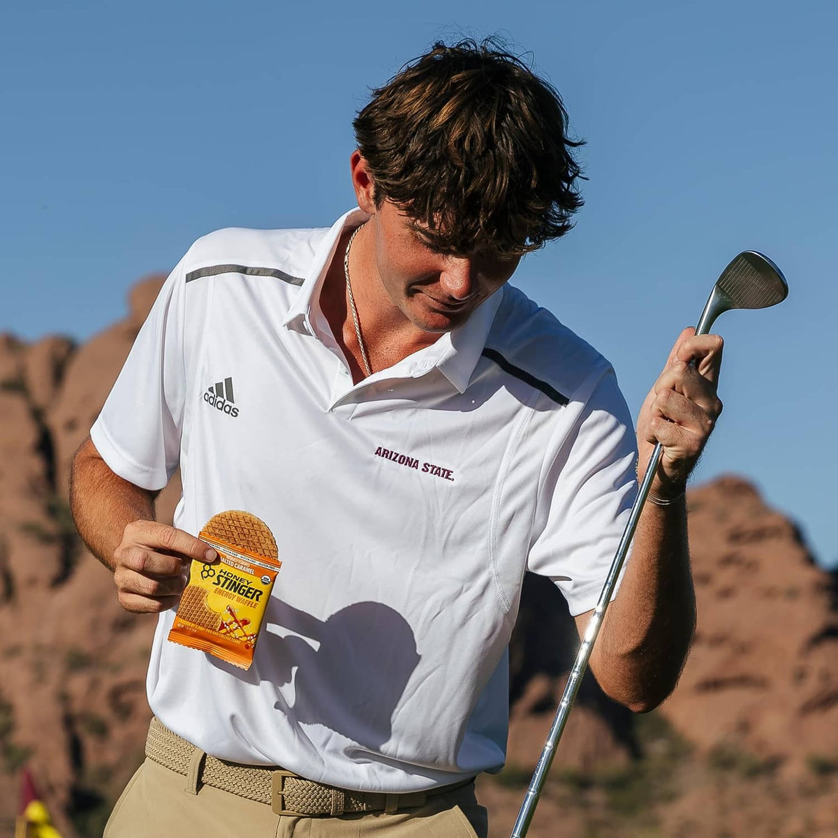 Gluten-free salted caramel energy waffle pack held by a golfer