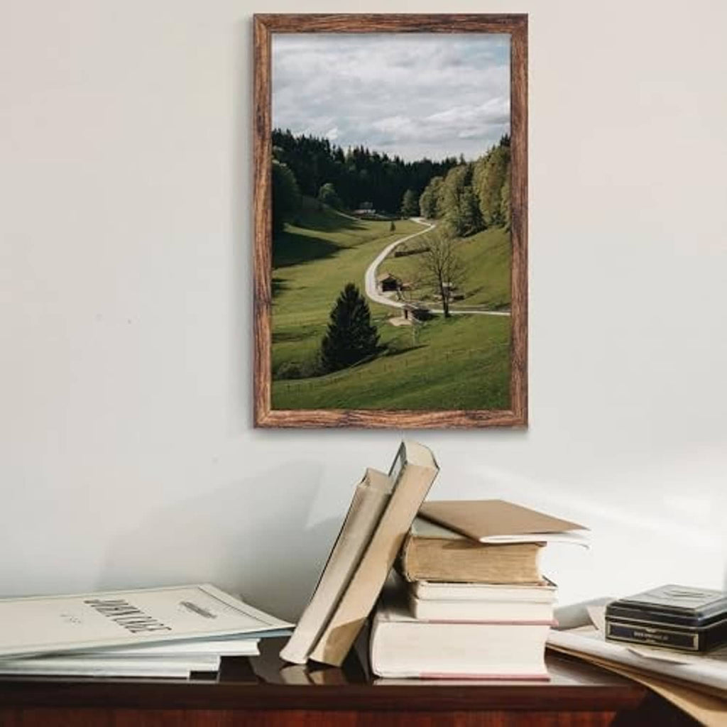 Brown picture frame with landscape photo, leaning upright for tabletop display