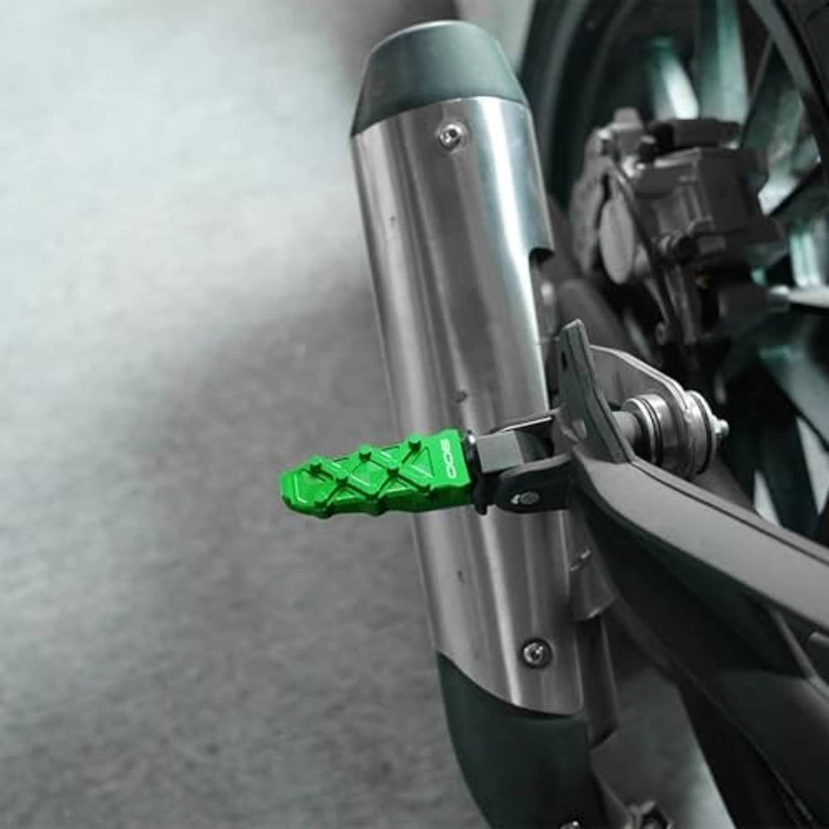 Motorcycle frame slider installed on front fork, showing green accent block