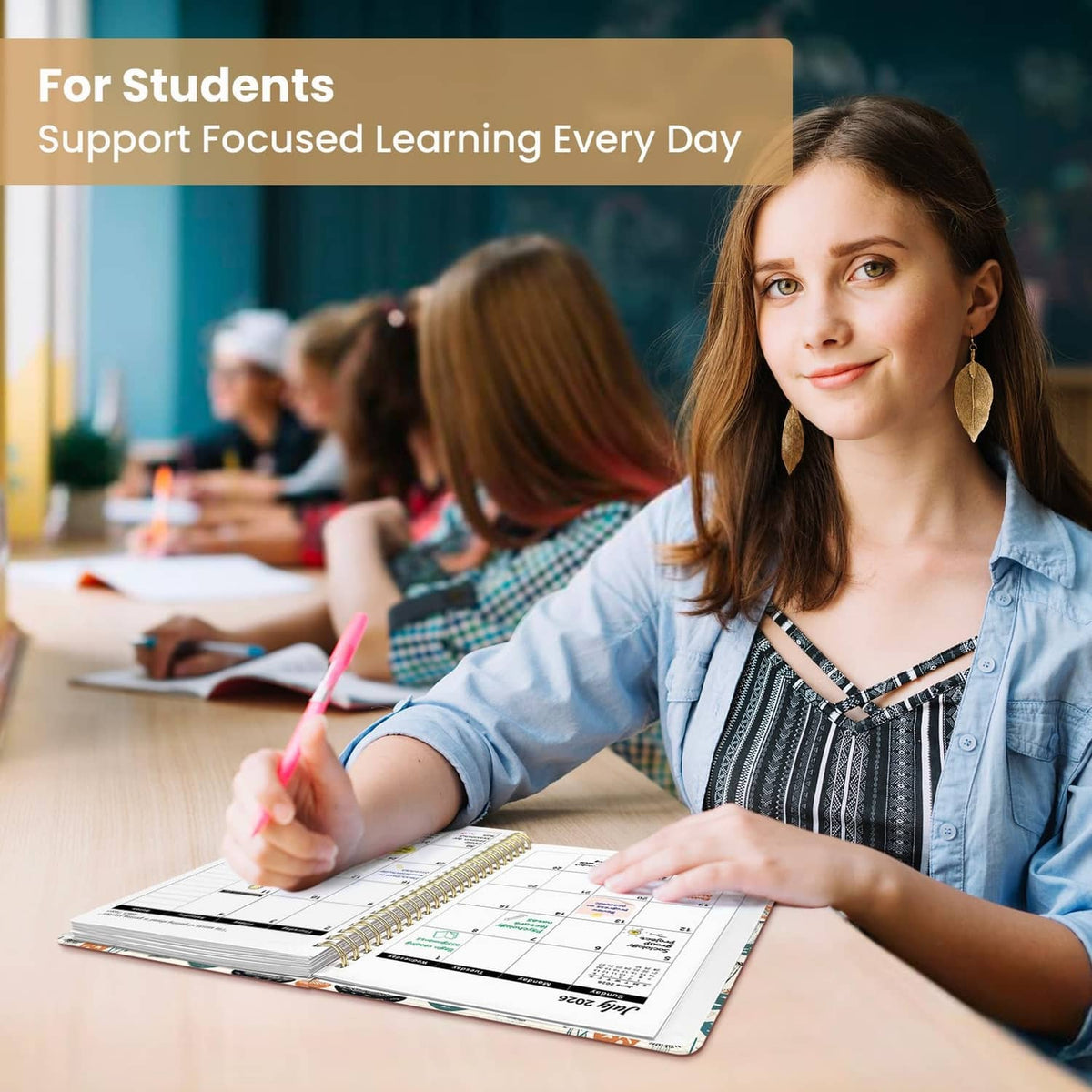 Student writing in academic planner with monthly calendar page on spiral binding
