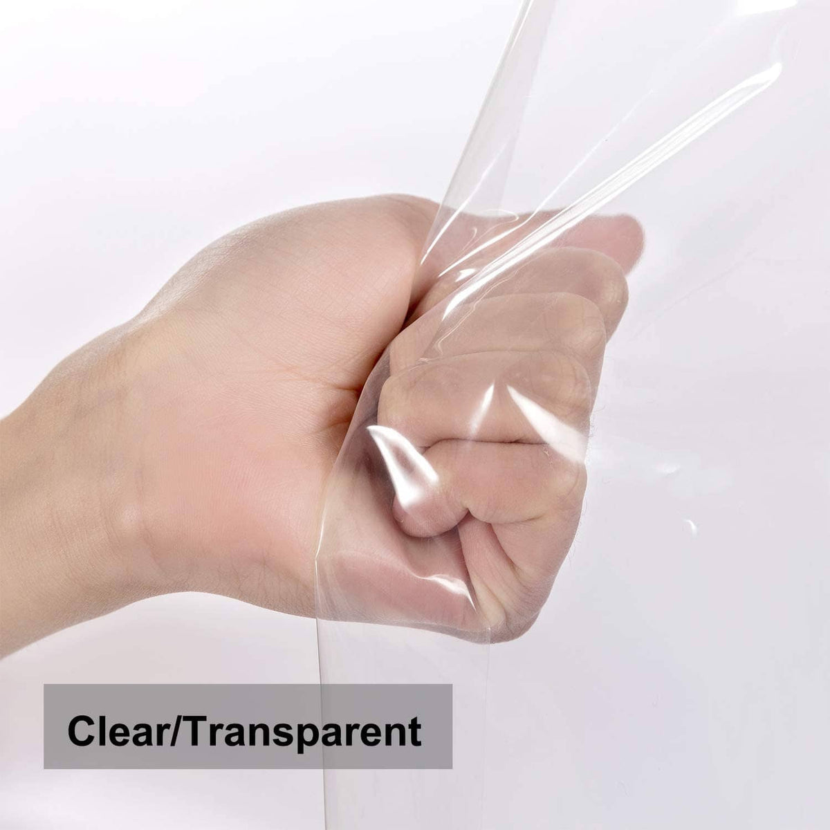 Transparent clear shower liner fabric pinched in hand to show flexible plastic sheet