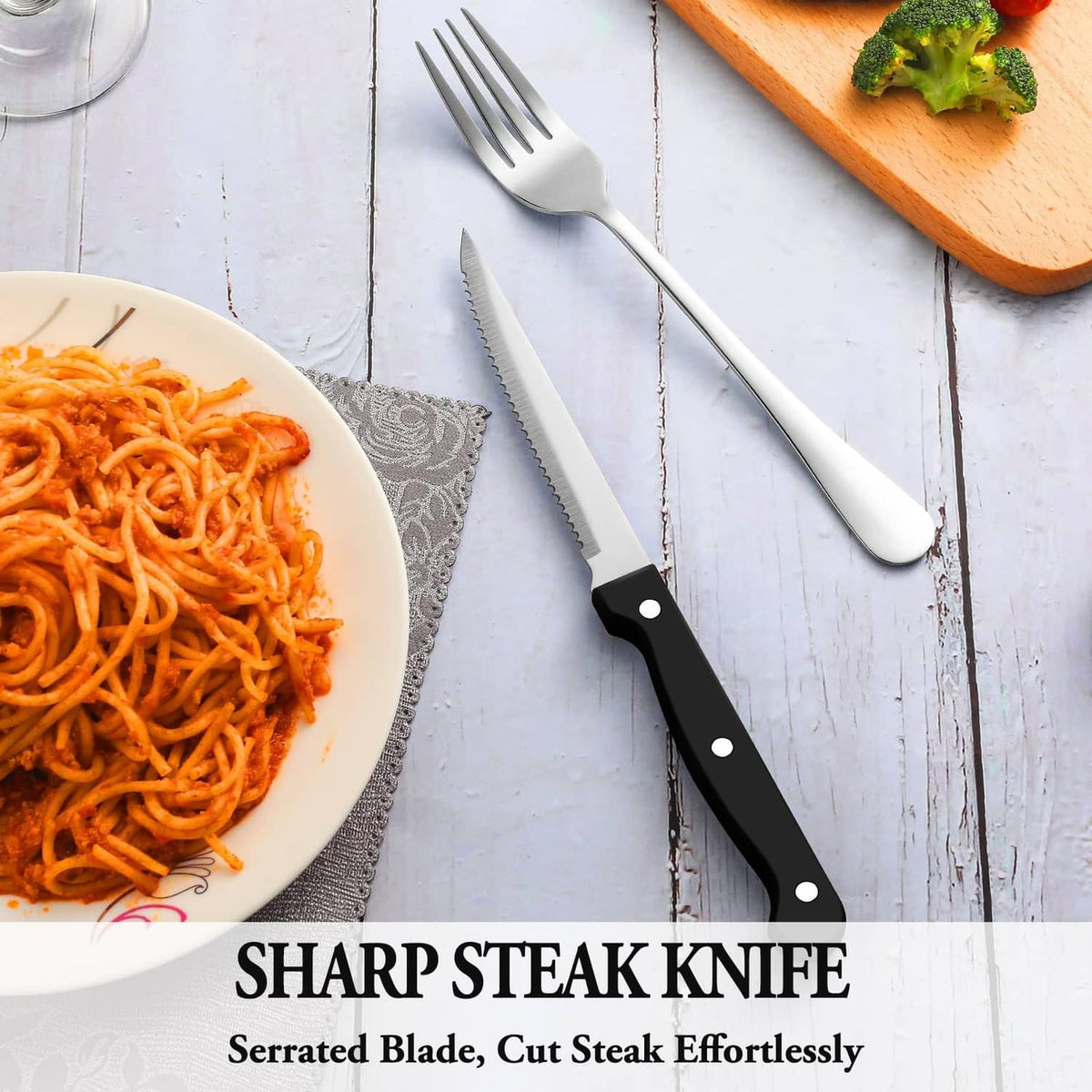 Stainless steel steak knife with serrated blade and black handle, with fork and spoon