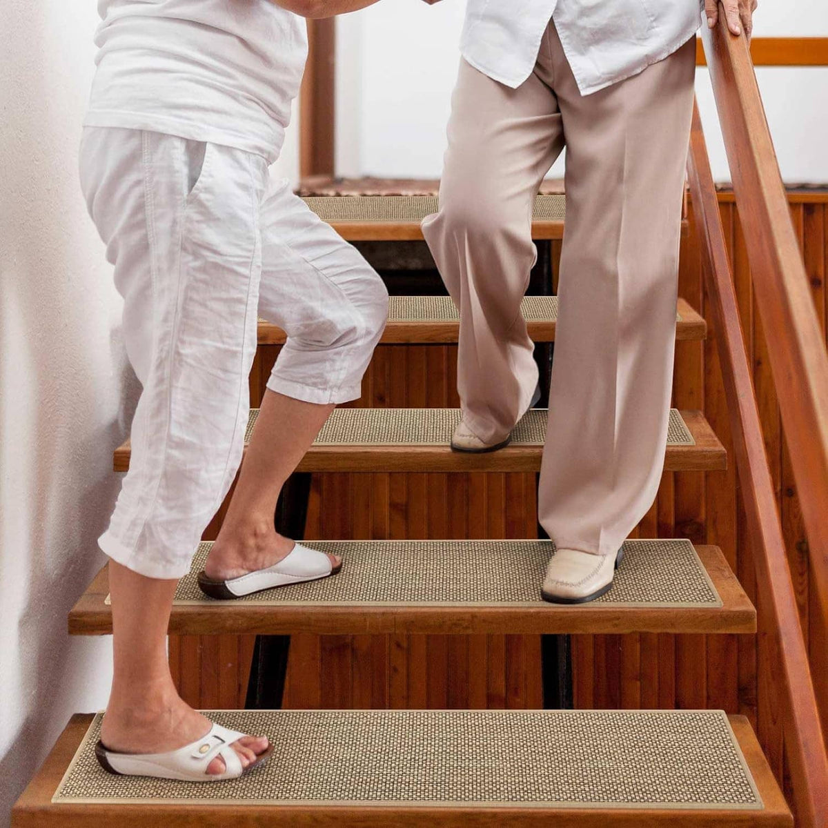 Beige non-slip stair tread carpet rectangles on indoor wooden stairs for walking