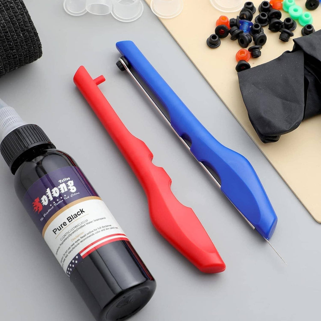 Tattoo kit supplies with black ink bottle, red and blue pen handles, and small ink caps