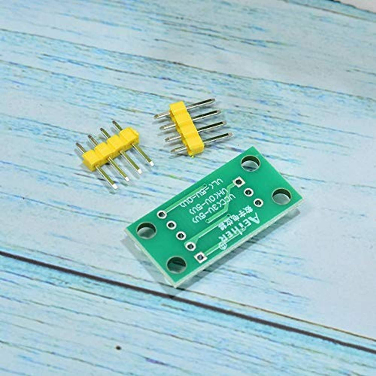 Green PCB digital potentiometer module with yellow pin header pieces and leads