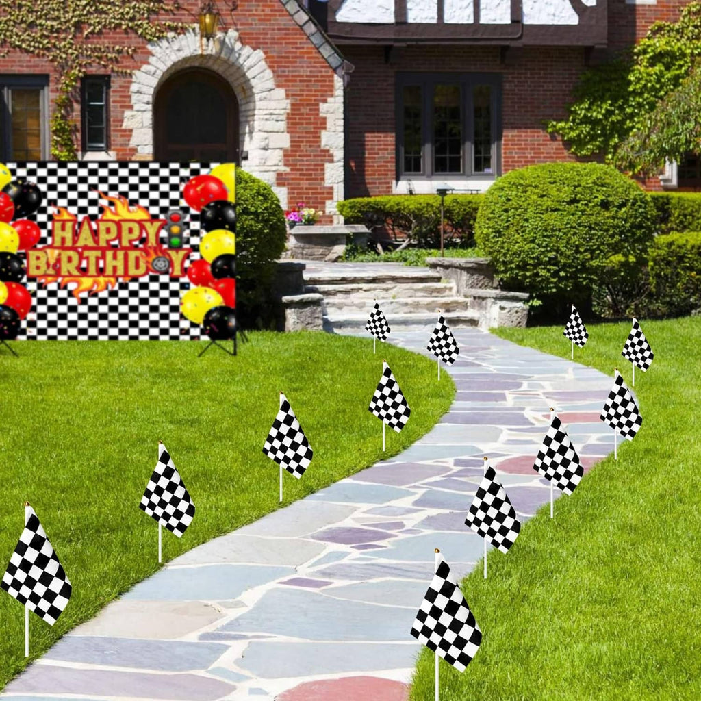 Black-and-white checkered race flags on sticks lining a garden walkway