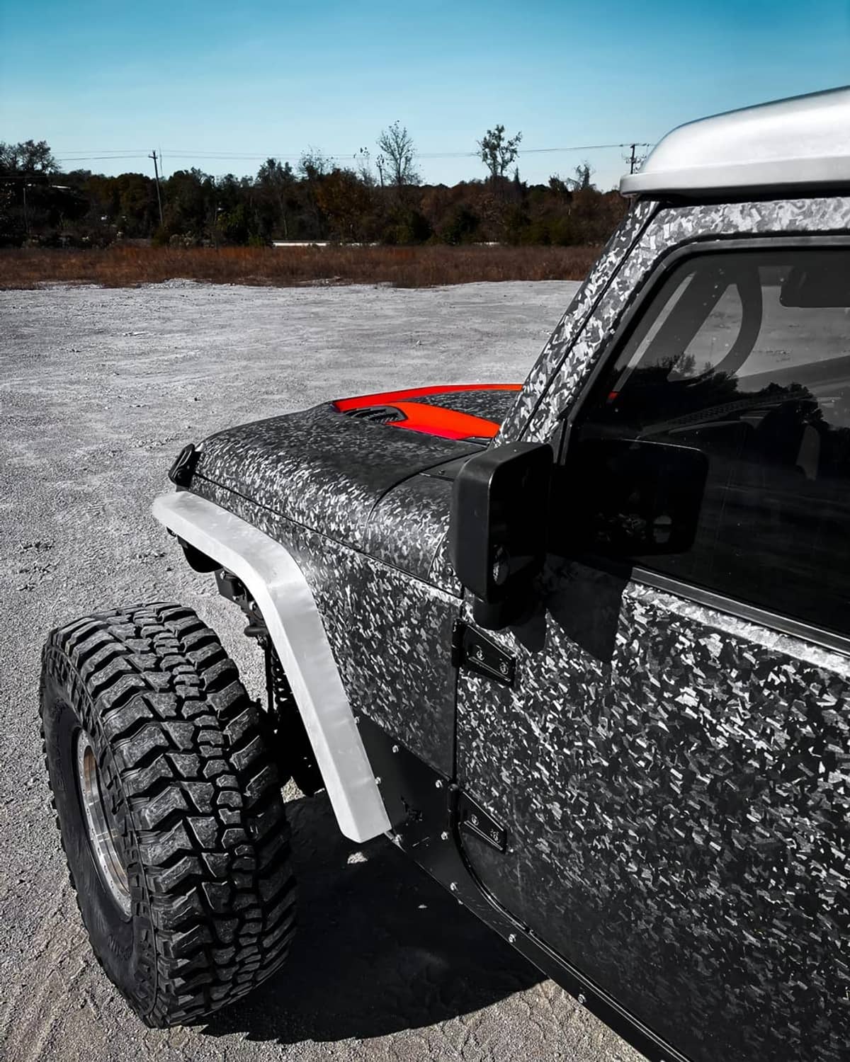 Gray metallic camo car vinyl wrap on side panel and hood, close-up