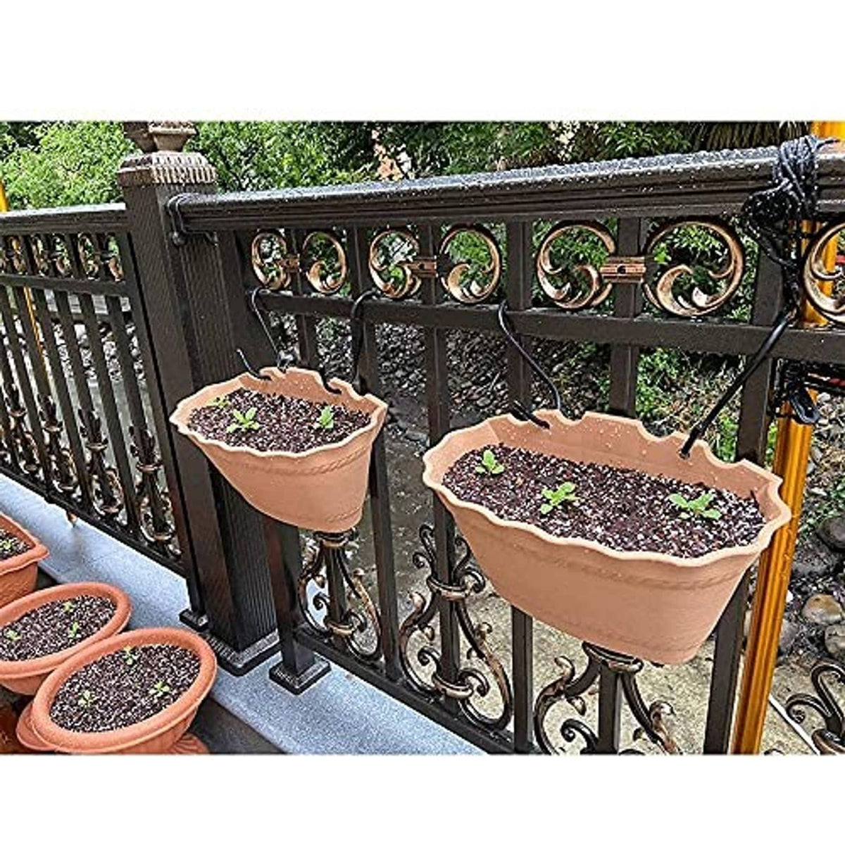 Black S hooks holding planters on an outdoor railing, curved hanging hooks