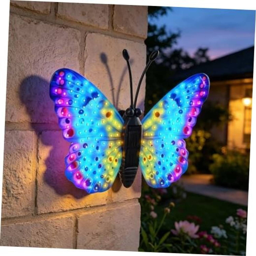 Solar LED butterfly wall decor with multicolor glowing wings, hanging on stone wall