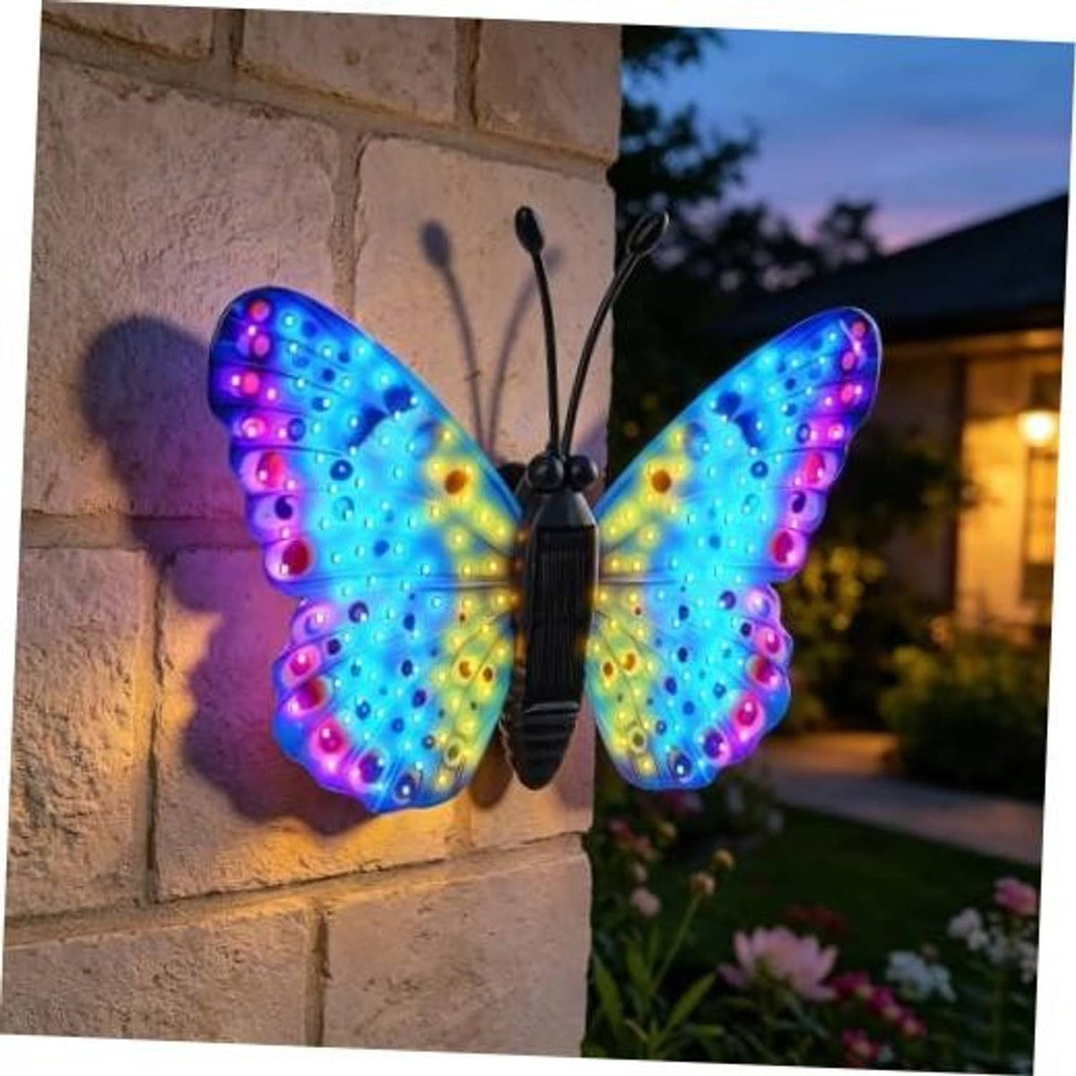 Solar LED butterfly wall decor with multicolor glowing wings, hanging on stone wall