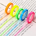 Colorful transparent highlighter tape rolls—orange, lime, green, blue, and pink—on paper