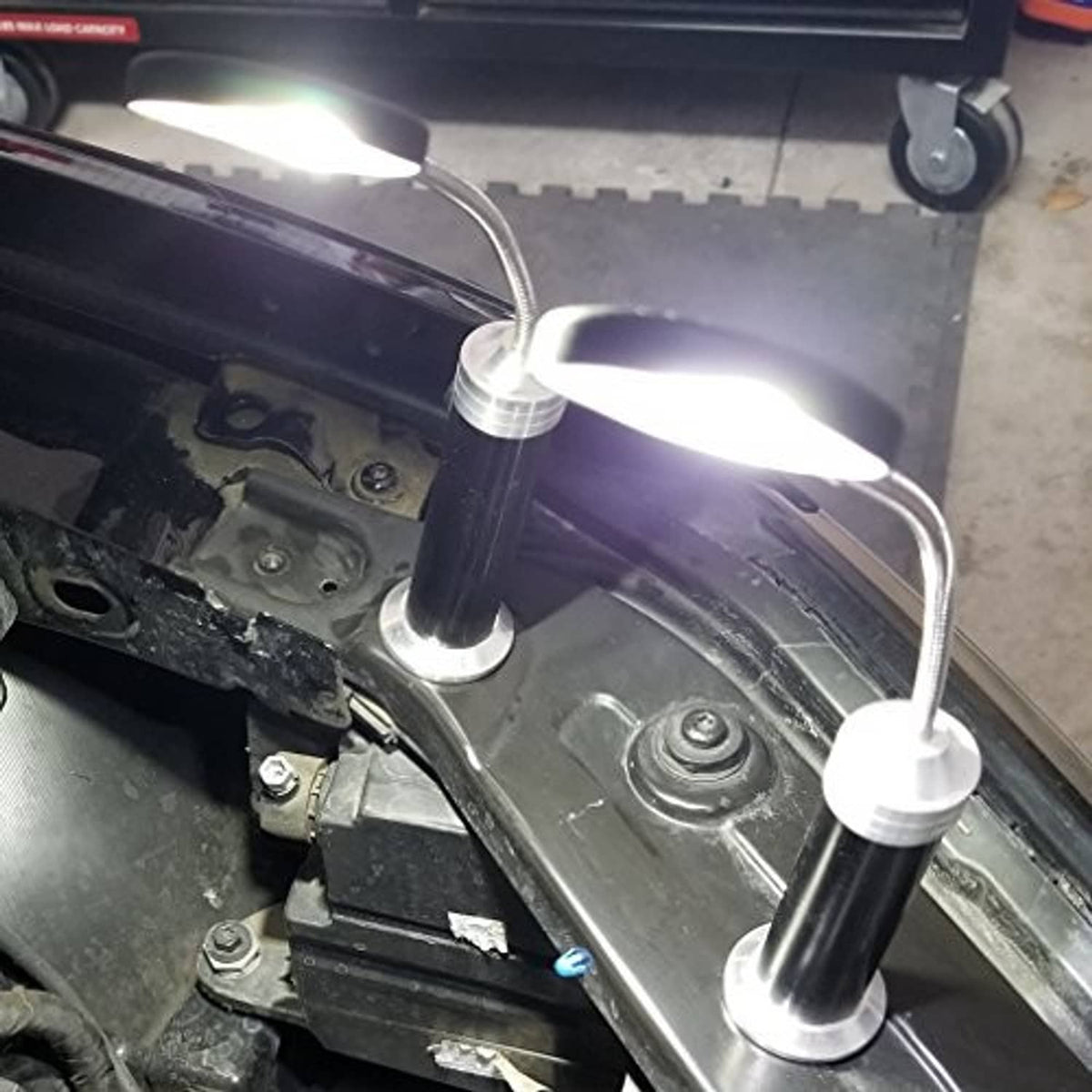 Magnetic LED COB light set glowing with three black magnetic pods on car engine bay