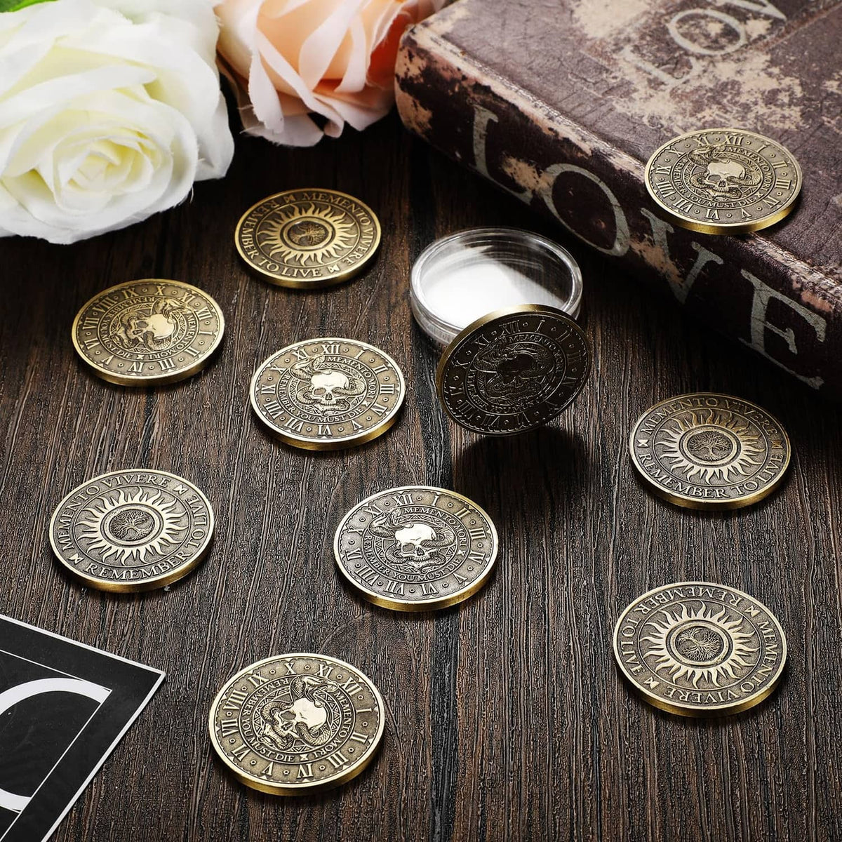 Copper memento mori coins scattered on a dark wood surface