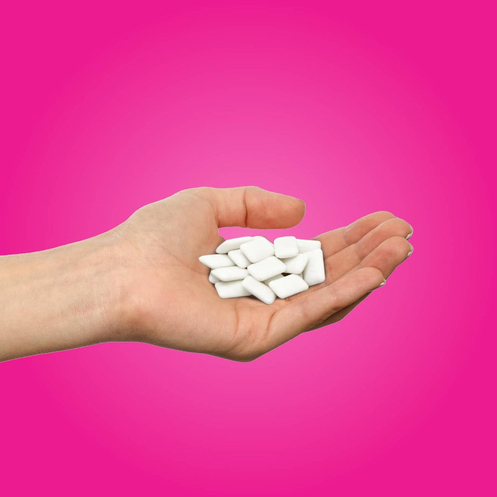 Xylitol gum pieces in hand, aspartame-free pomegranate mint flavor