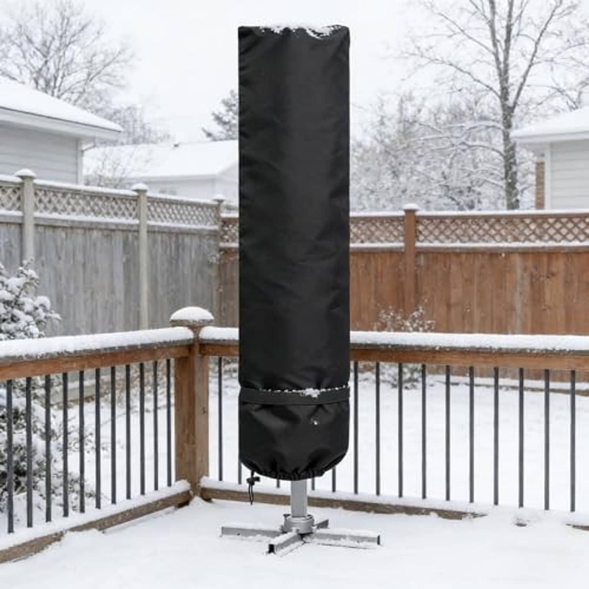 Black patio umbrella cover over umbrella in snowy outdoor setting, cinched hem