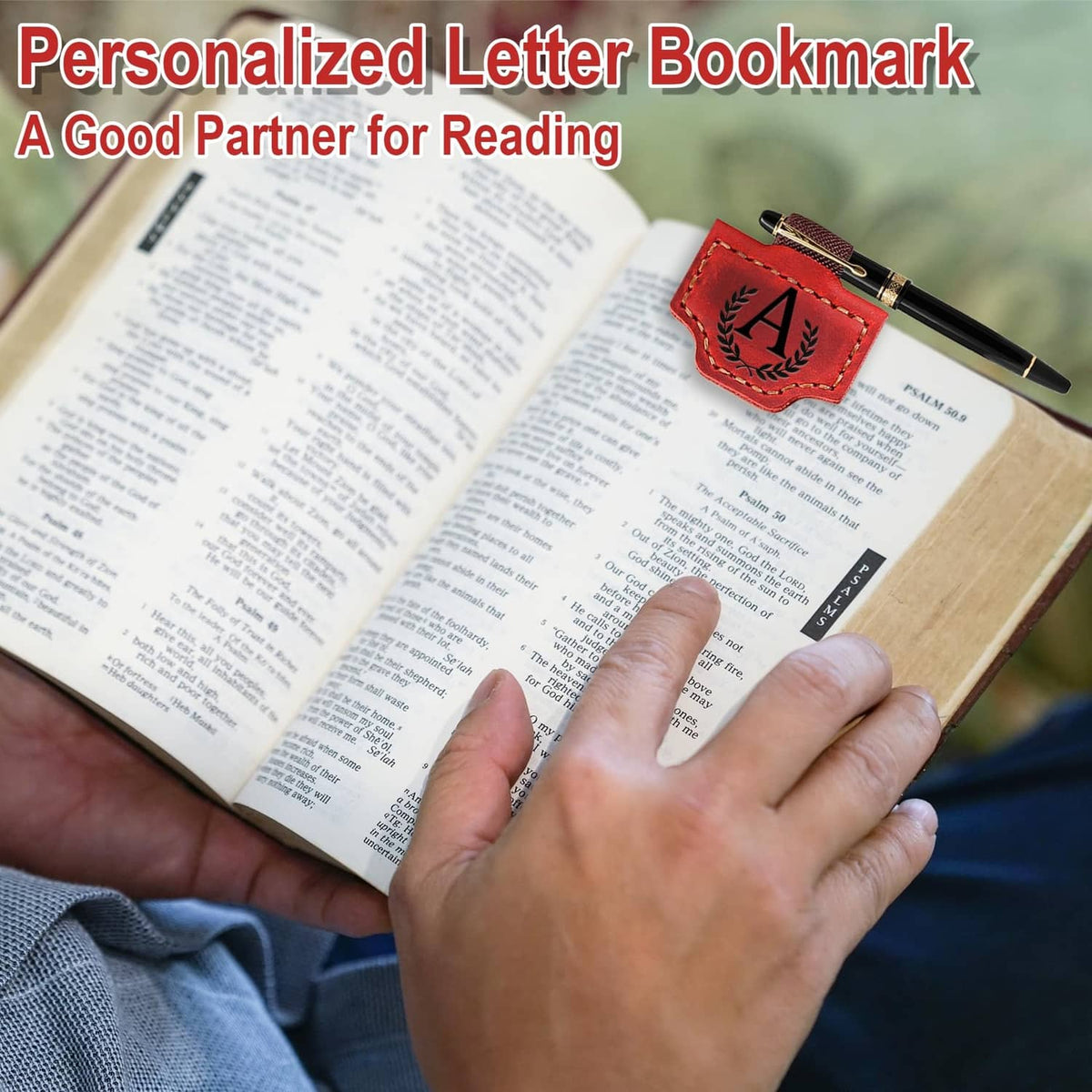 Brown leather magnetic bookmark with letter A patch holding a pen on an open book