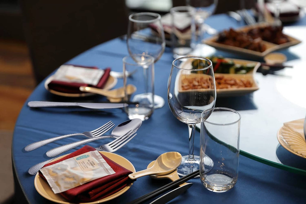 Stainless steel cutlery set laid out on place settings, silver finish