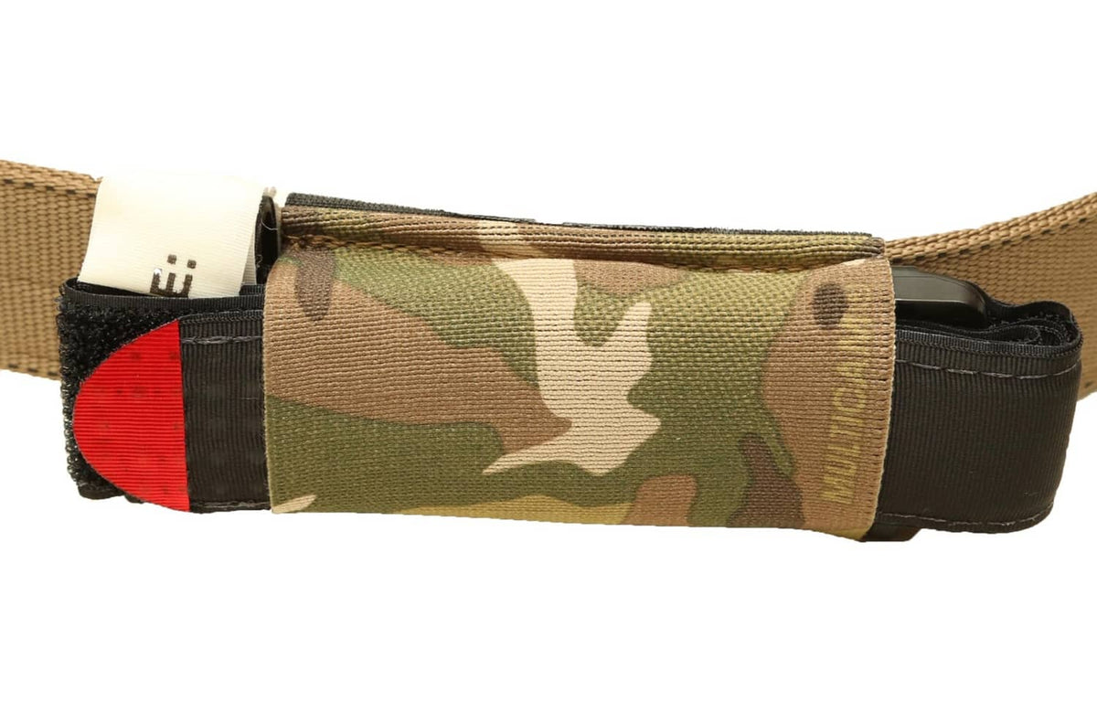 Multicam tourniquet pouch with black sleeve, elastic band, and red accent at edge