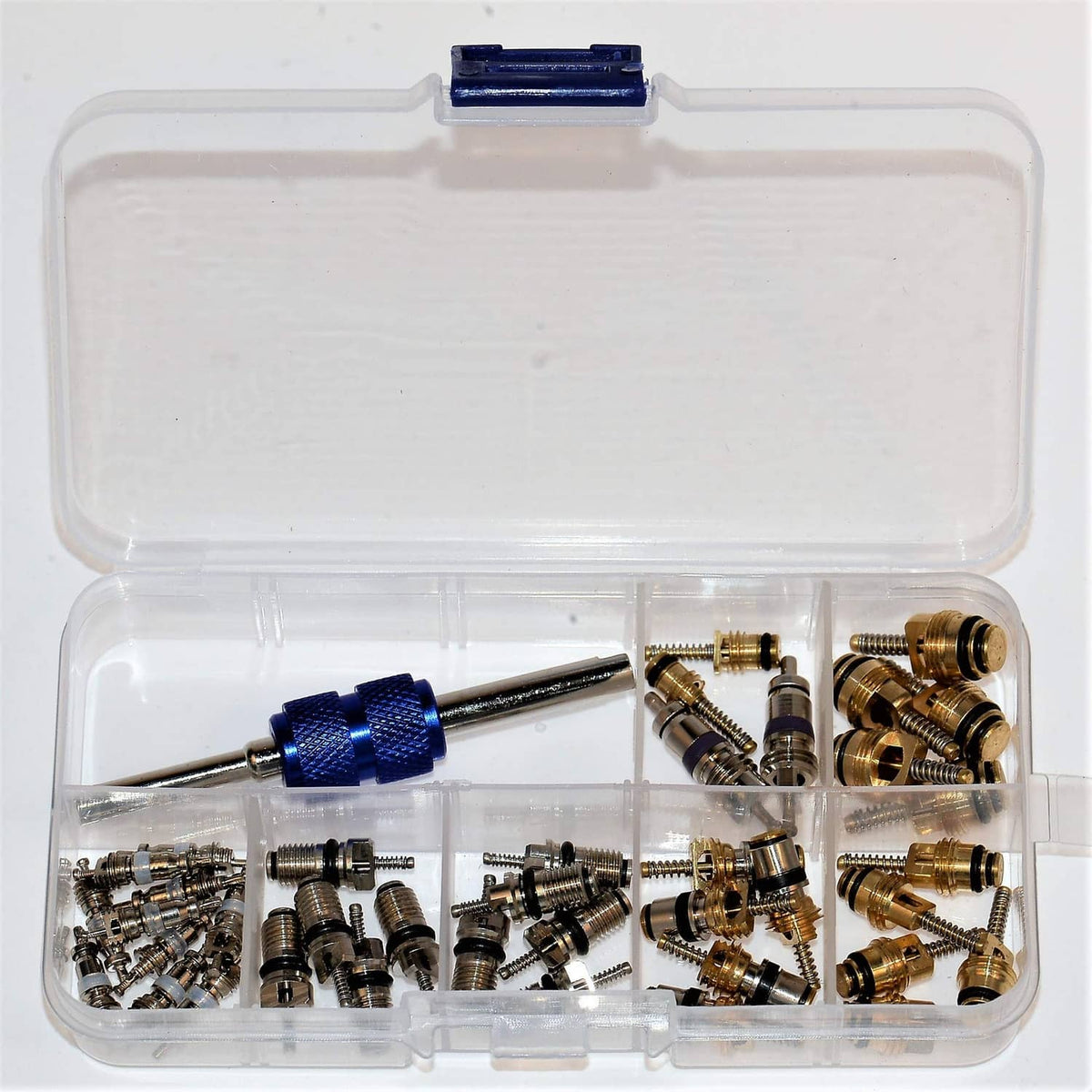 Transparent kit box with blue tool, green O-rings, and mixed brass valve cores.