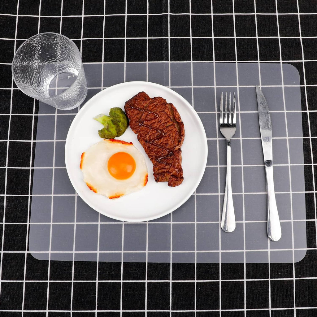 Clear matte plastic placemat with rounded corners under a dinner plate