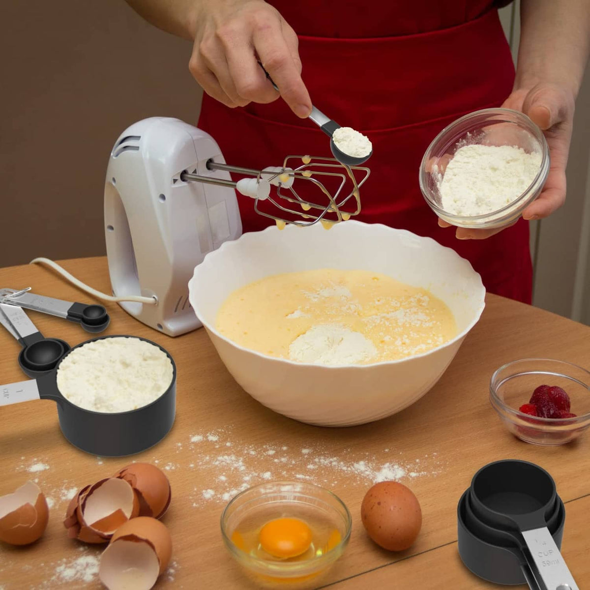 Black stackable measuring cups and spoons set with spoon scoop and cups on countertop