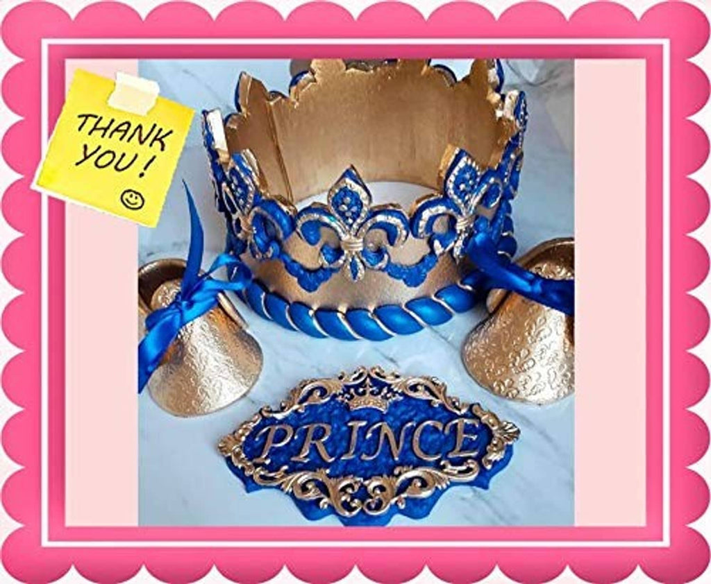 Gold glitter crown on blue cake with blue trim and “PRINCE” plaque