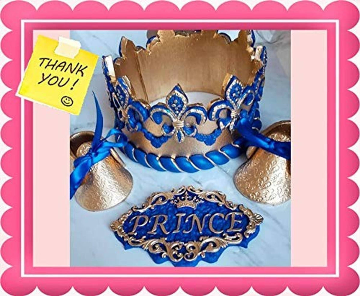 Gold glitter crown on blue cake with blue trim and “PRINCE” plaque