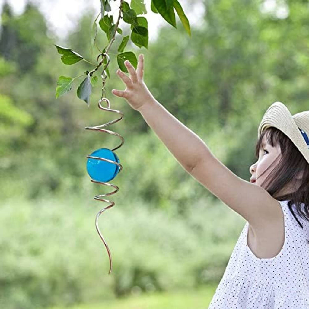 Blue glass orb spiral wind spinner held outdoors with hanging chain