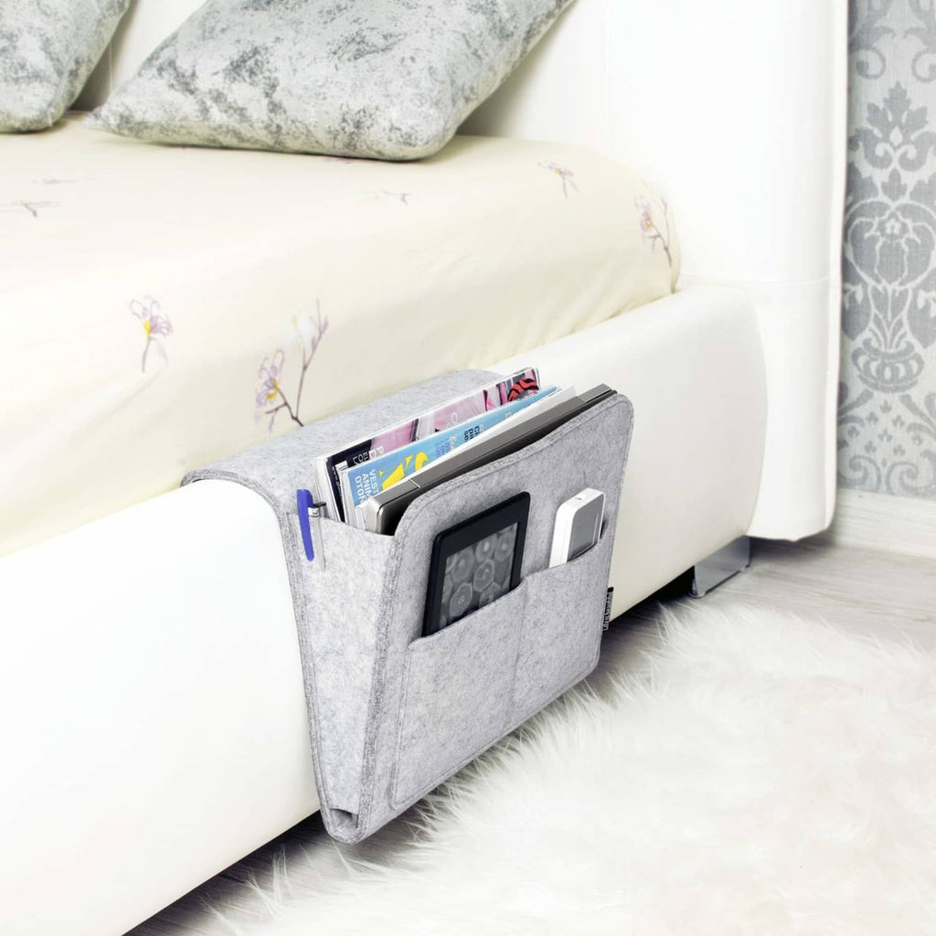 Light gray felt bedside storage caddy attached to sofa arm for books and tablet
