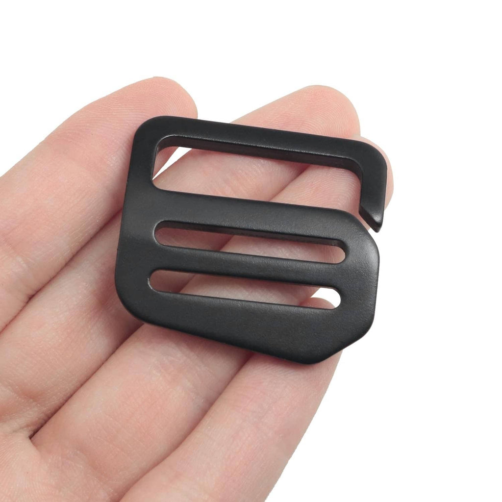Black wave button buckle held in hand, showing rectangular slots
