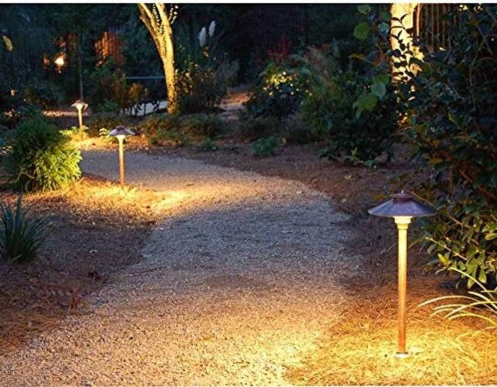 Outdoor landscape path lights glowing with warm-cool white light along a walkway.