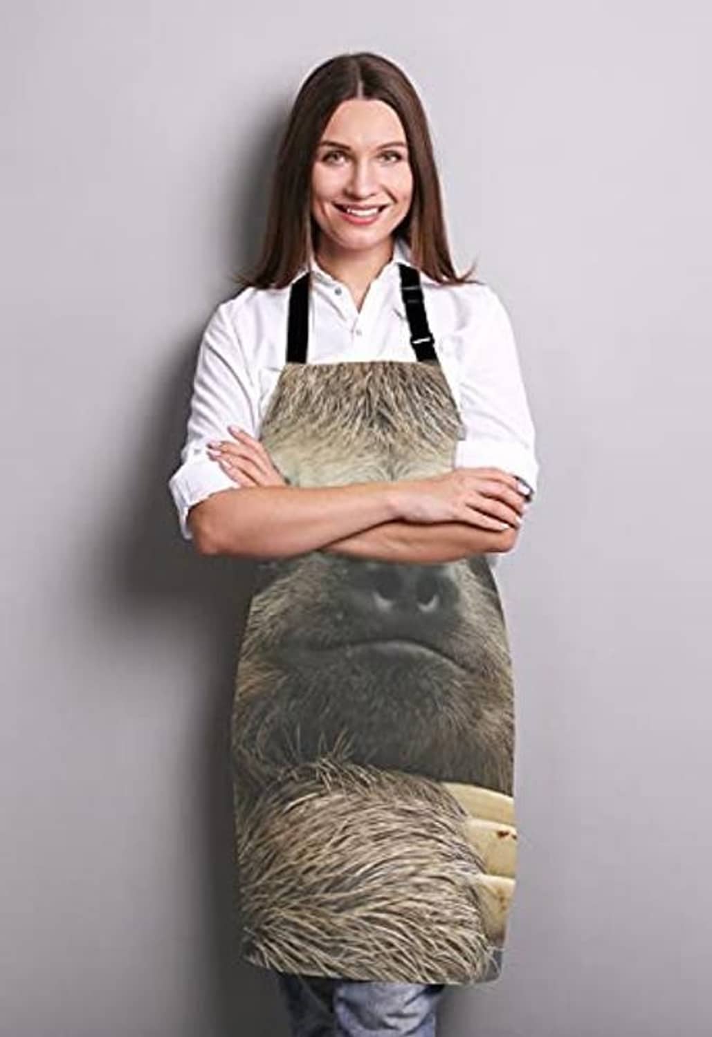 Sloth-print cooking apron on person wearing white chef shirt, black neck straps and ties