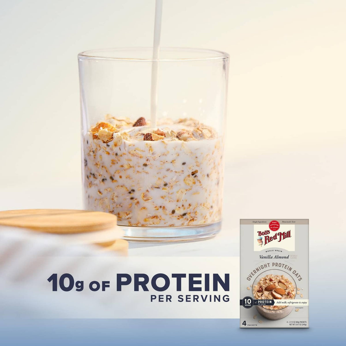 Glass of overnight protein oats with milk pour beside vanilla almond 4-pack packet