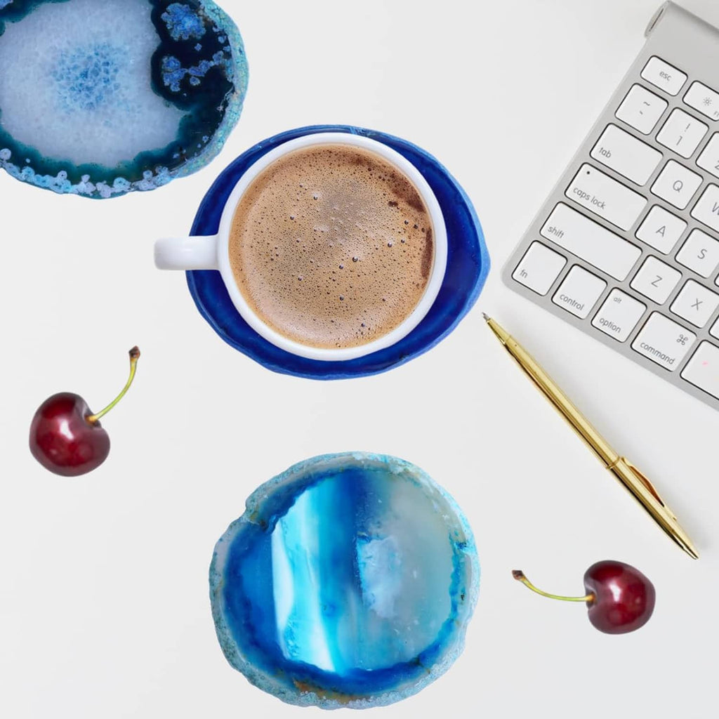 Blue agate geode coasters with one under a cup of coffee on a desk surface