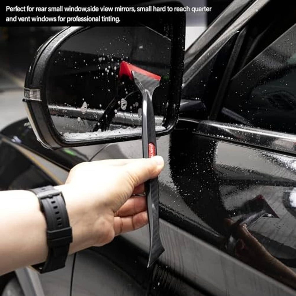 Window tint squeegee tool with red edge held to a car side window and mirror