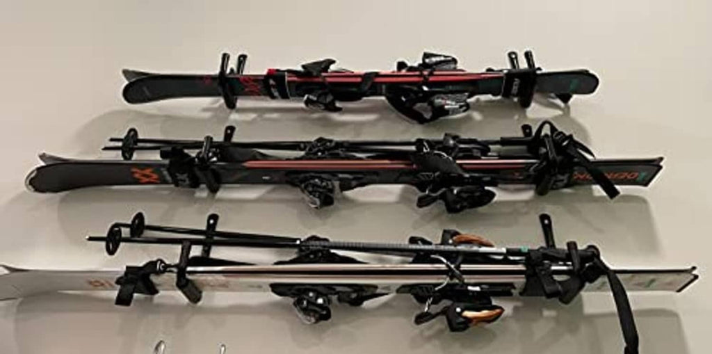 Multiple black wall hooks mounted together, holding long tools horizontally