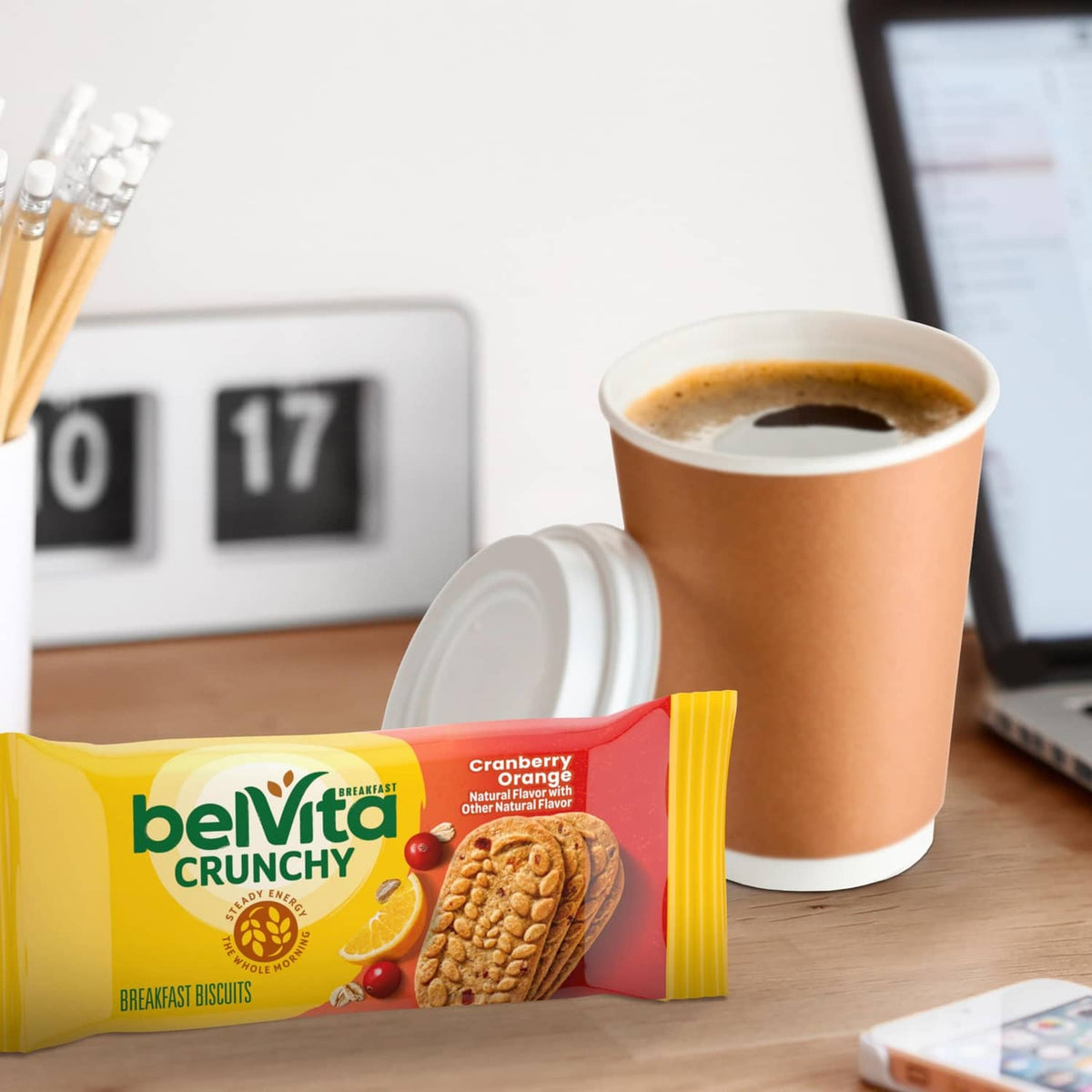 Belvita Crunchy cranberry-orange breakfast biscuits single pack beside coffee cup