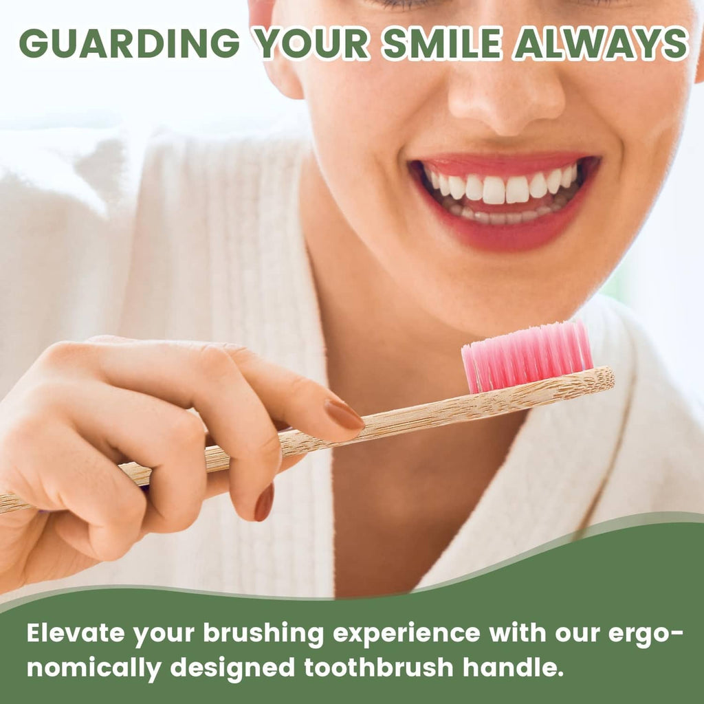 Woman holding bamboo toothbrush with pink bristles and an ergonomic wooden handle