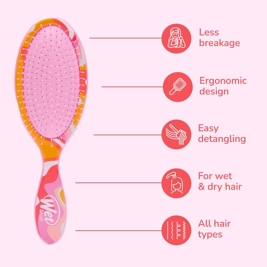 Oval pink detangling hair brush with cushioned pad and patterned handle.
