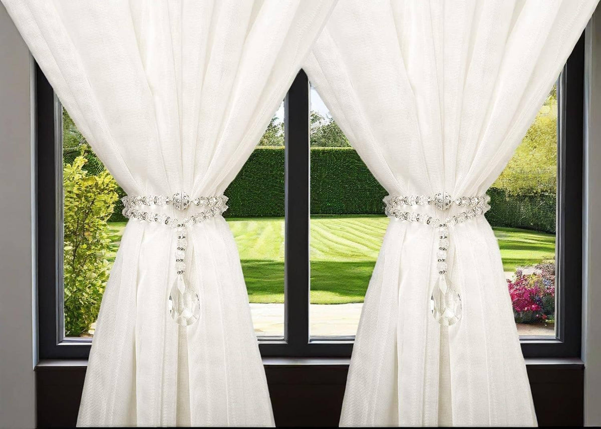 Crystal beaded curtain tiebacks clasped around the curtain, each with teardrop pendant