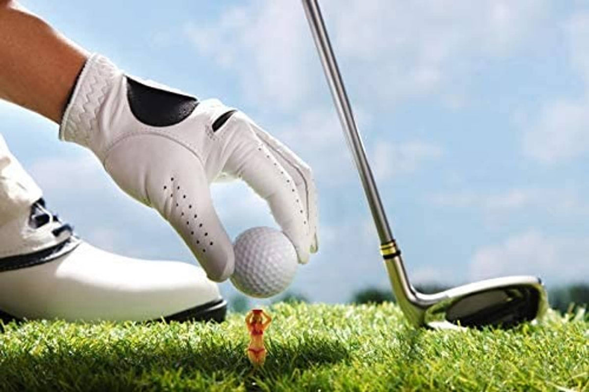 Golf tee with white ball head held near turf by a gloved golfer