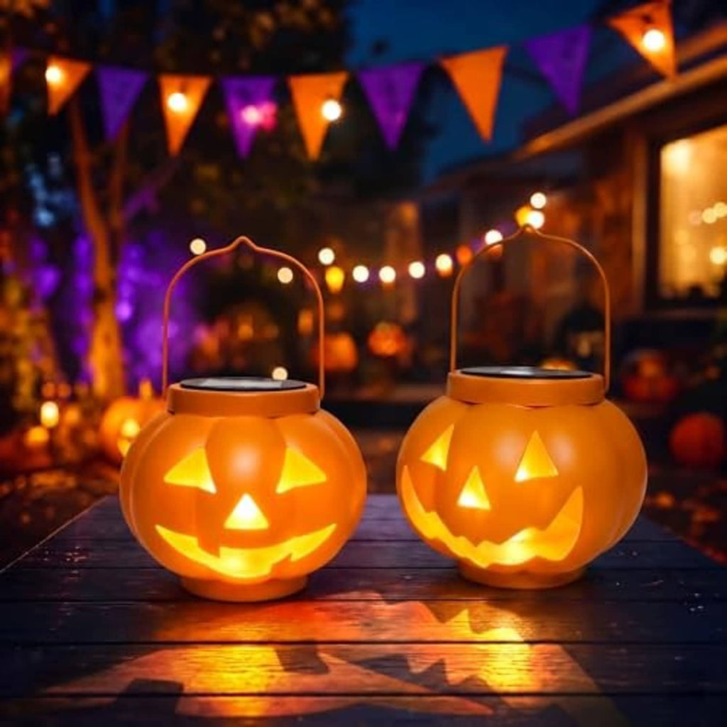 Two glowing orange jack-o'-lantern solar lanterns on a wooden surface with handles