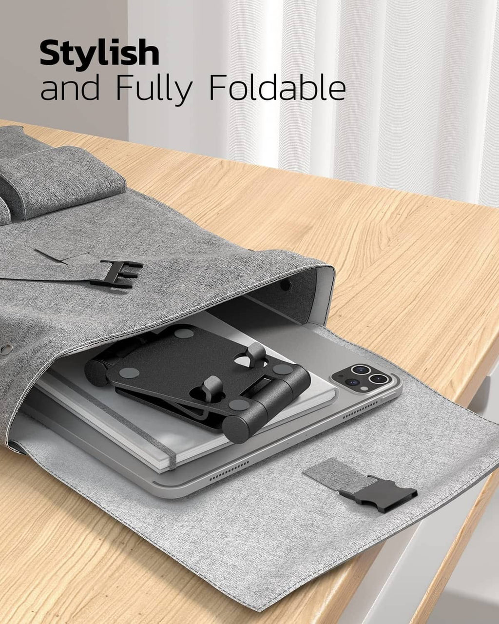 Foldable black phone stand with base and cradle, stored in a gray fabric pouch