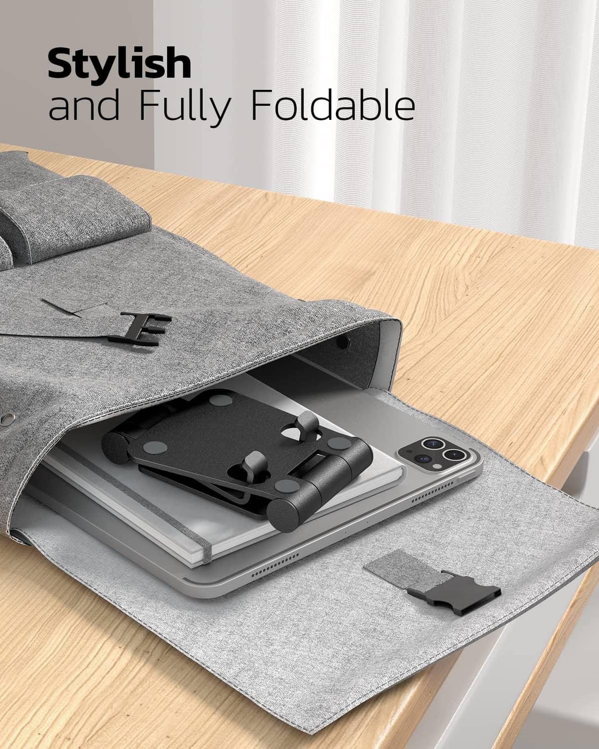 Foldable black phone stand with base and cradle, stored in a gray fabric pouch